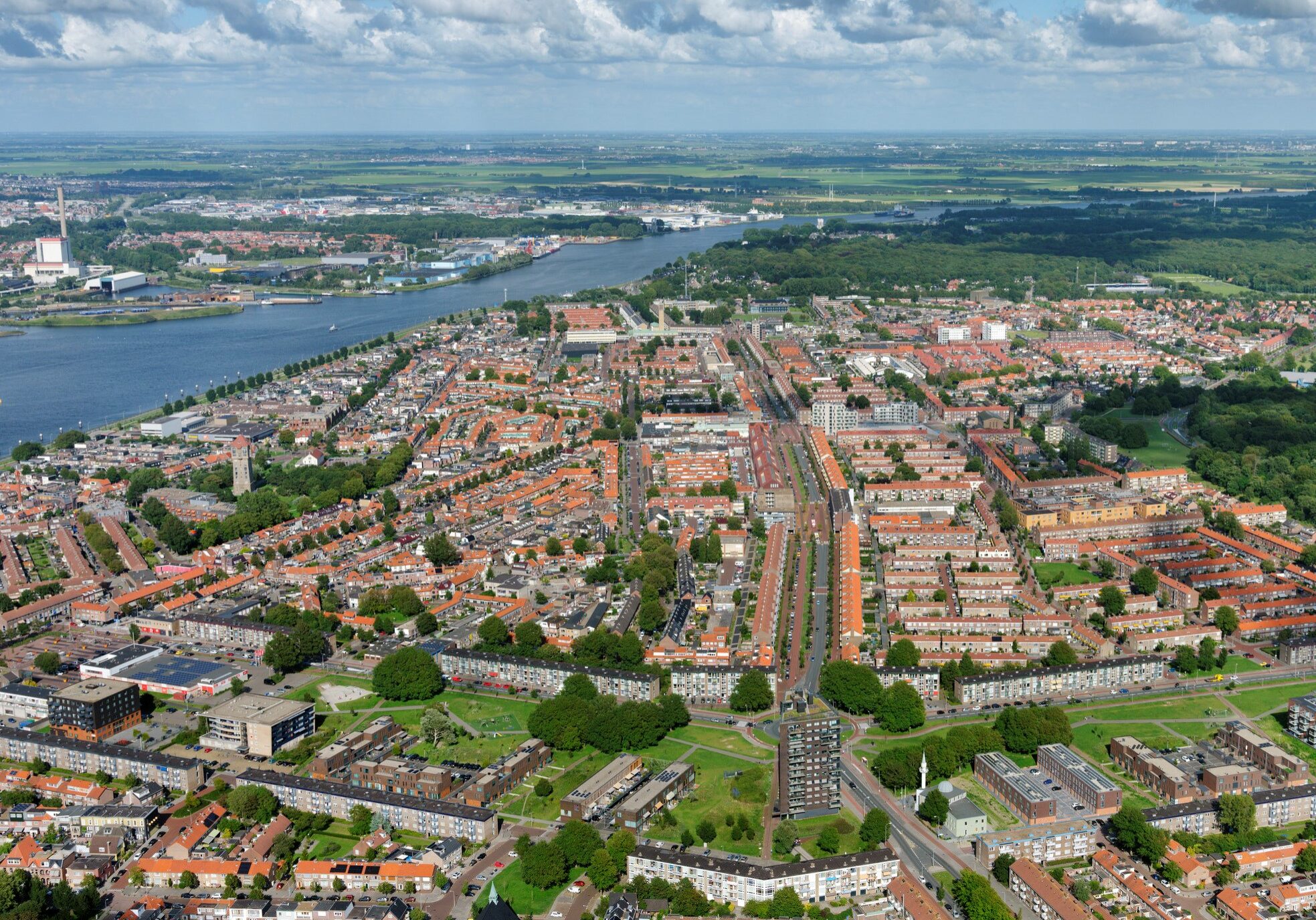 IJmuiden was tijdens de oorlog grotendeels verwoest voor de aanleg van Festung (fortress, fort) IJmuiden onderdeel van de Atlatikwall. Na de oorlog heeft Willem Dudok Oost IJmuiden een nieuw gezicht gegeven, Oud IJmuiden was voorbestemd  als industrie en haven gebied. Midden door het beeld de Lange Nieuwstraat ©  20 juli 2020 Aerophoto-Schiphol Luchtfotografie 